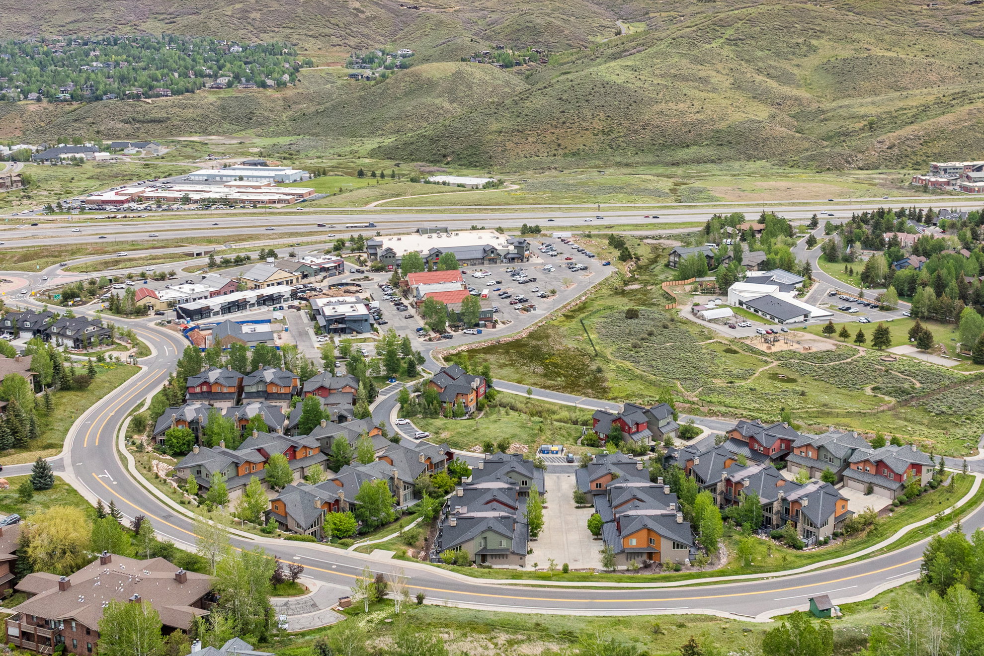 Residential development featuring multiple multi-story townhomes with dark roofs and varied exterior finishes