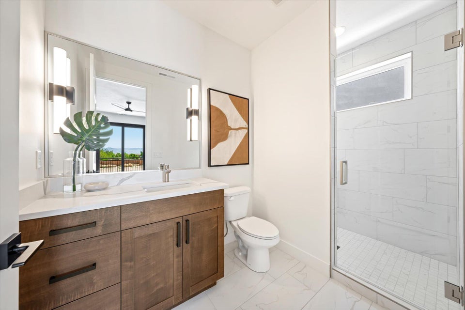 Contemporary bathroom featuring a wood-finish vanity with a white countertop and rectangular undermount sink