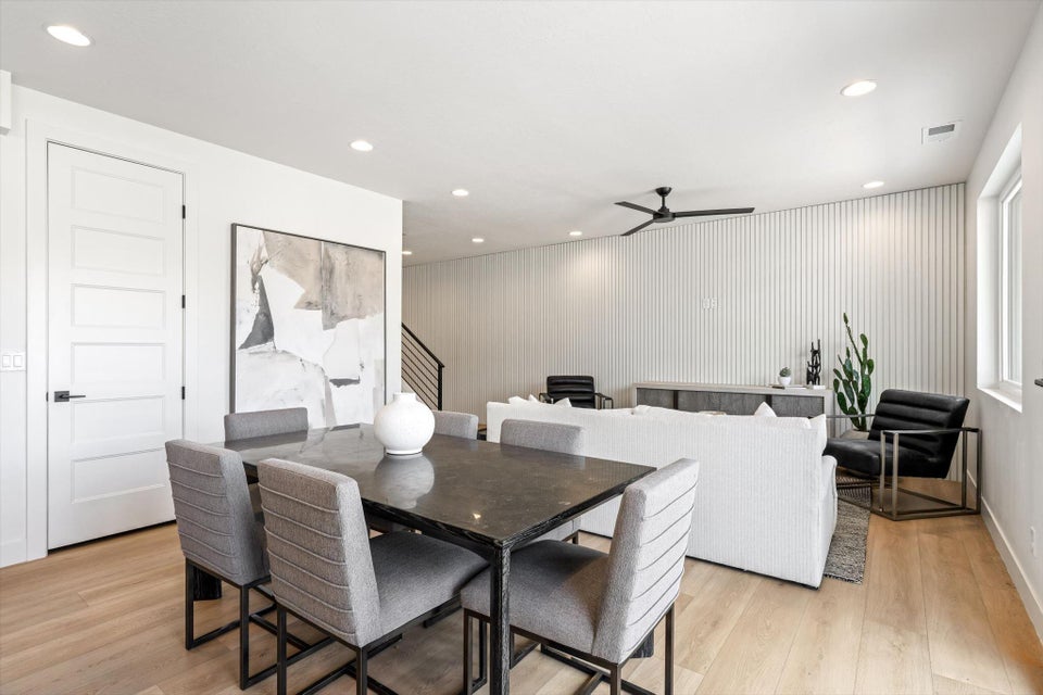 Dining area with light wood-finish flooring, recessed lighting, and a contemporary five-panel door