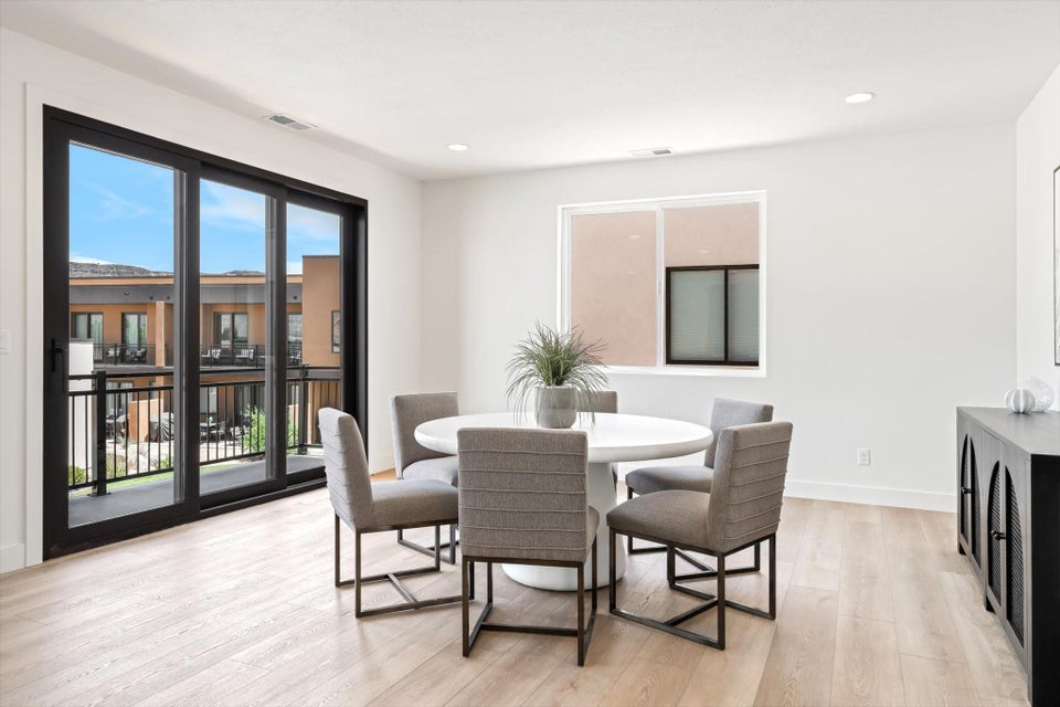 Spacious room featuring light wood-finish flooring, recessed lighting, and a white color palette