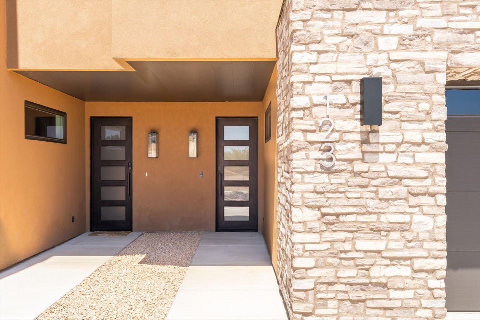 Modern exterior featuring a stucco facade and a stacked stone accent wall