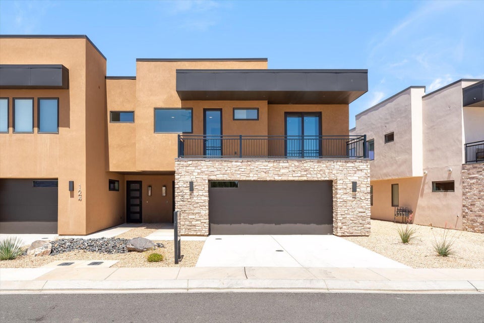 Modern stucco exterior featuring a flat roofline and integrated garage