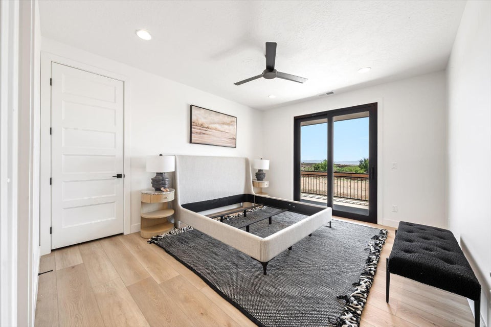 Light-filled room featuring wood-finish flooring, a modern ceiling fan, recessed lighting, and a five-panel interior door