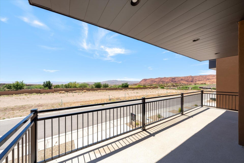 Covered outdoor patio featuring a concrete surface and black metal railing