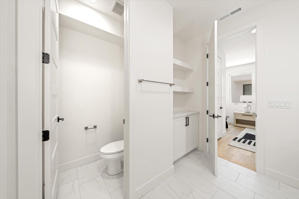 Contemporary bathroom featuring large format white tile flooring with subtle veining