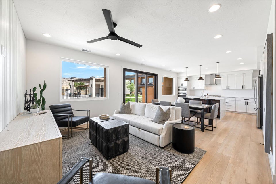 Open-concept living area featuring light wood-finish flooring, recessed lighting, and a contemporary ceiling fan