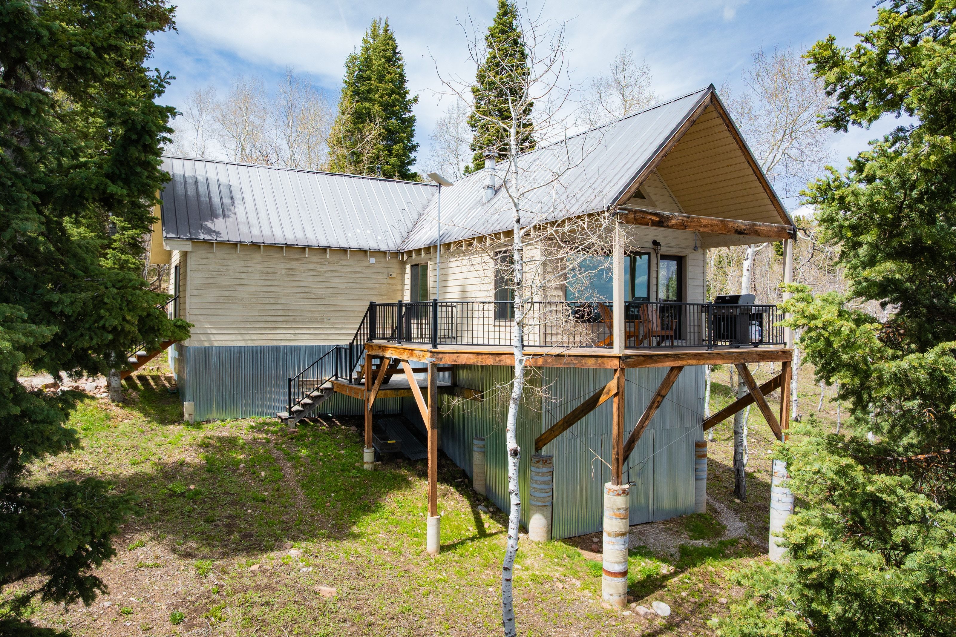 Back of property featuring a metal roof and a wooden deck