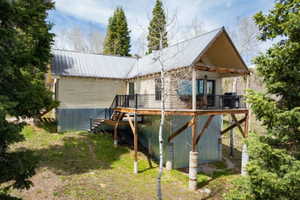 Back of property featuring a metal roof and a wooden deck