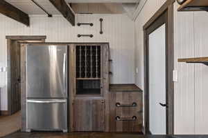 Kitchen with freestanding refrigerator and beam ceiling