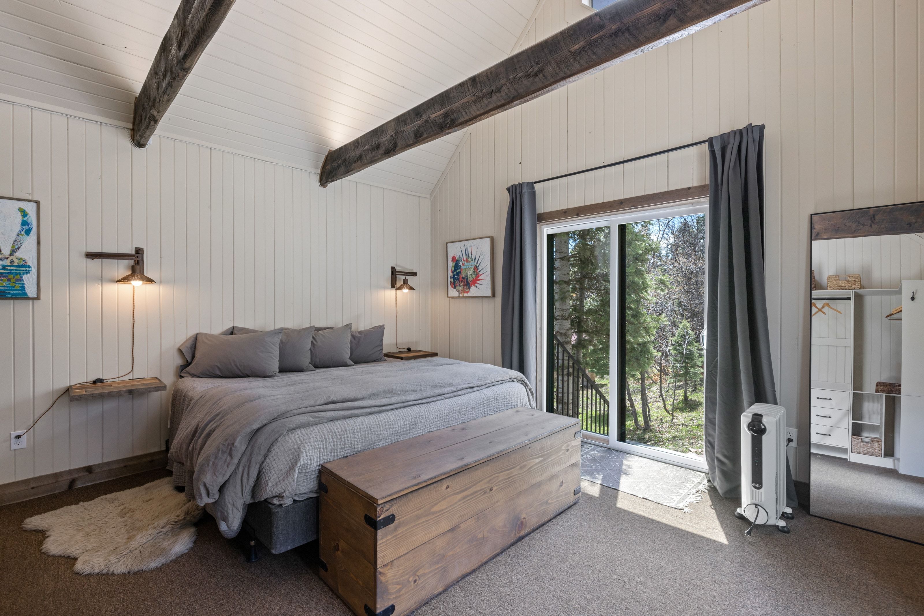 Bedroom with carpet, wood walls, lofted ceiling with beams, and access to outside