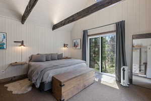 Bedroom with carpet, wood walls, lofted ceiling with beams, and access to outside