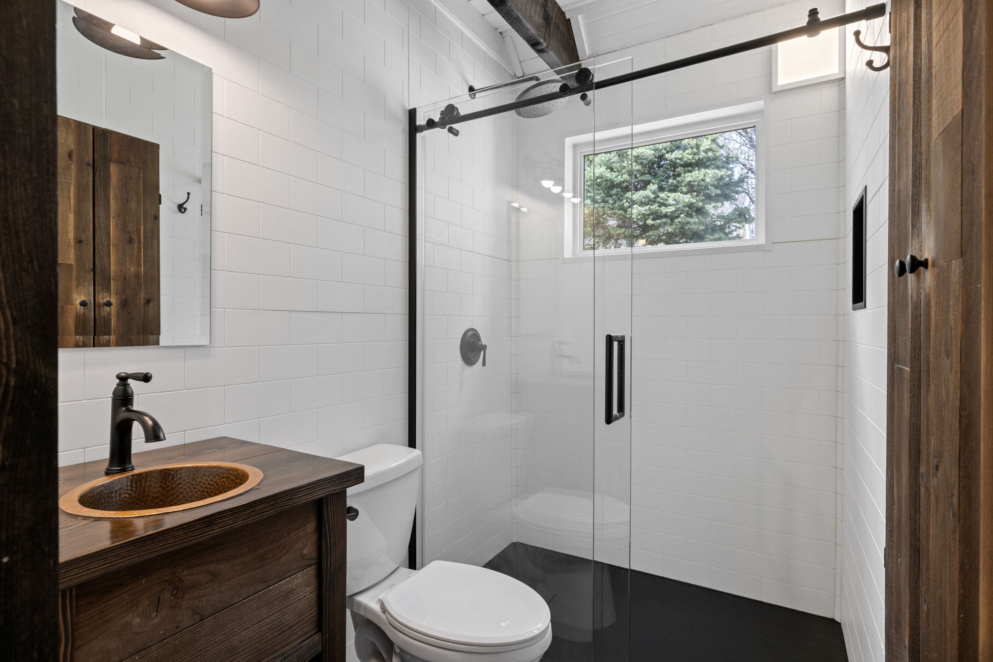 Bathroom featuring tile walls, vanity, and a shower stall