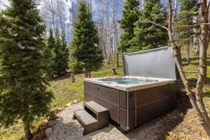 View of yard featuring a hot tub and view of wooded area