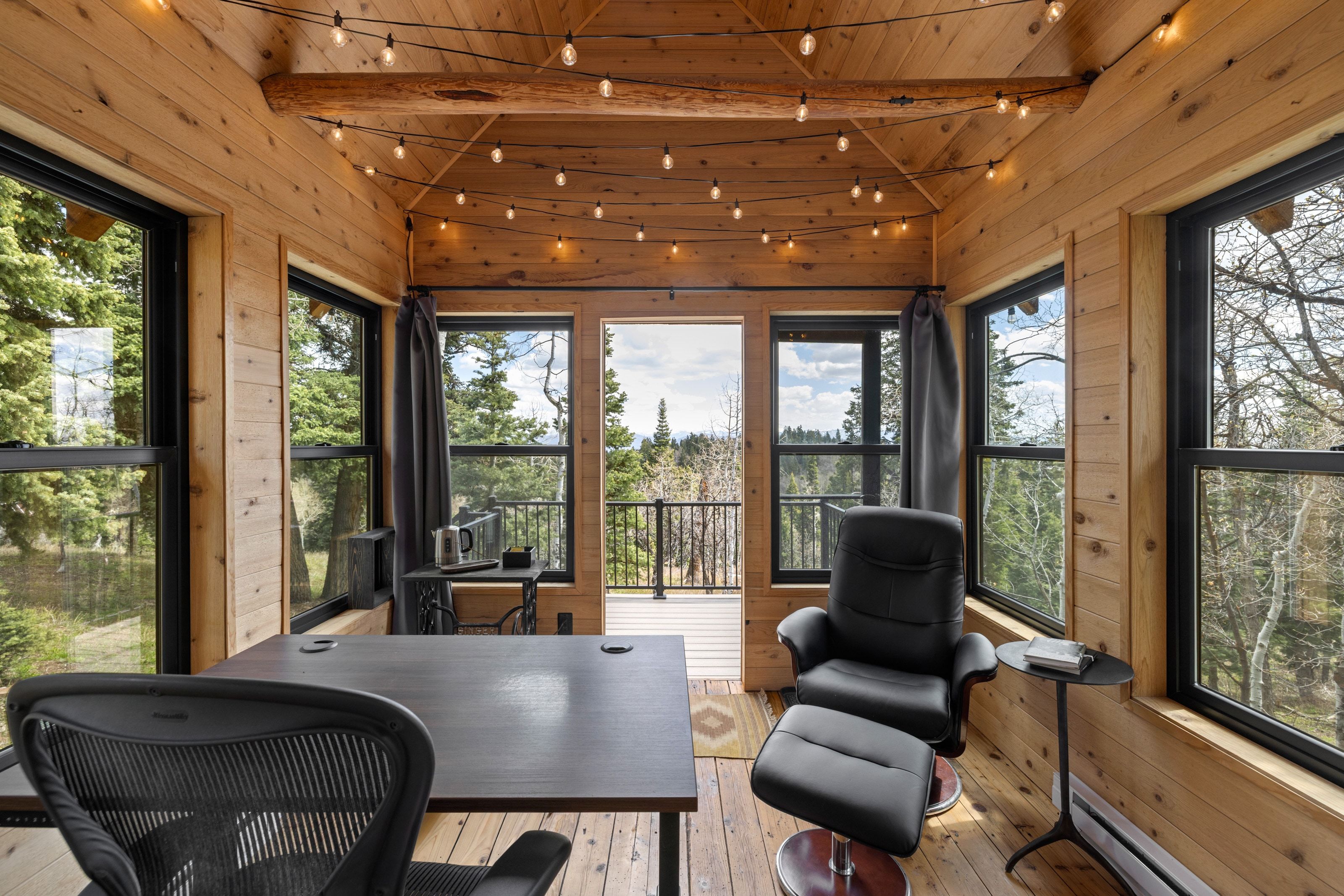 Home office with wood walls, wood-type flooring, vaulted ceiling with beams, plenty of natural light, and baseboard heating