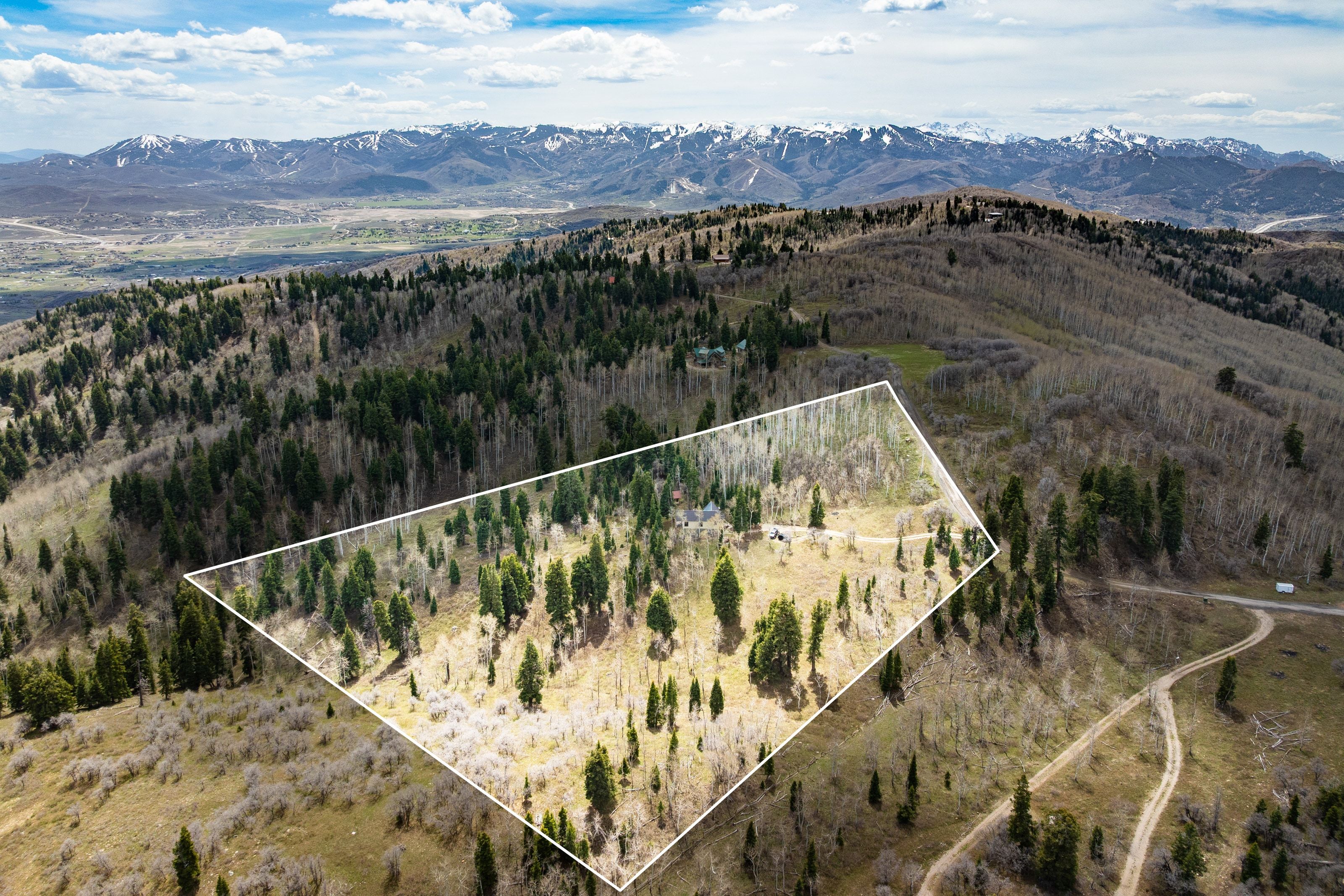 Aerial view of property and surrounding area with property boundaries highlighted and a mountainous background