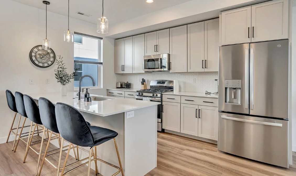 Modern kitchen featuring light wood-finish flooring and white walls