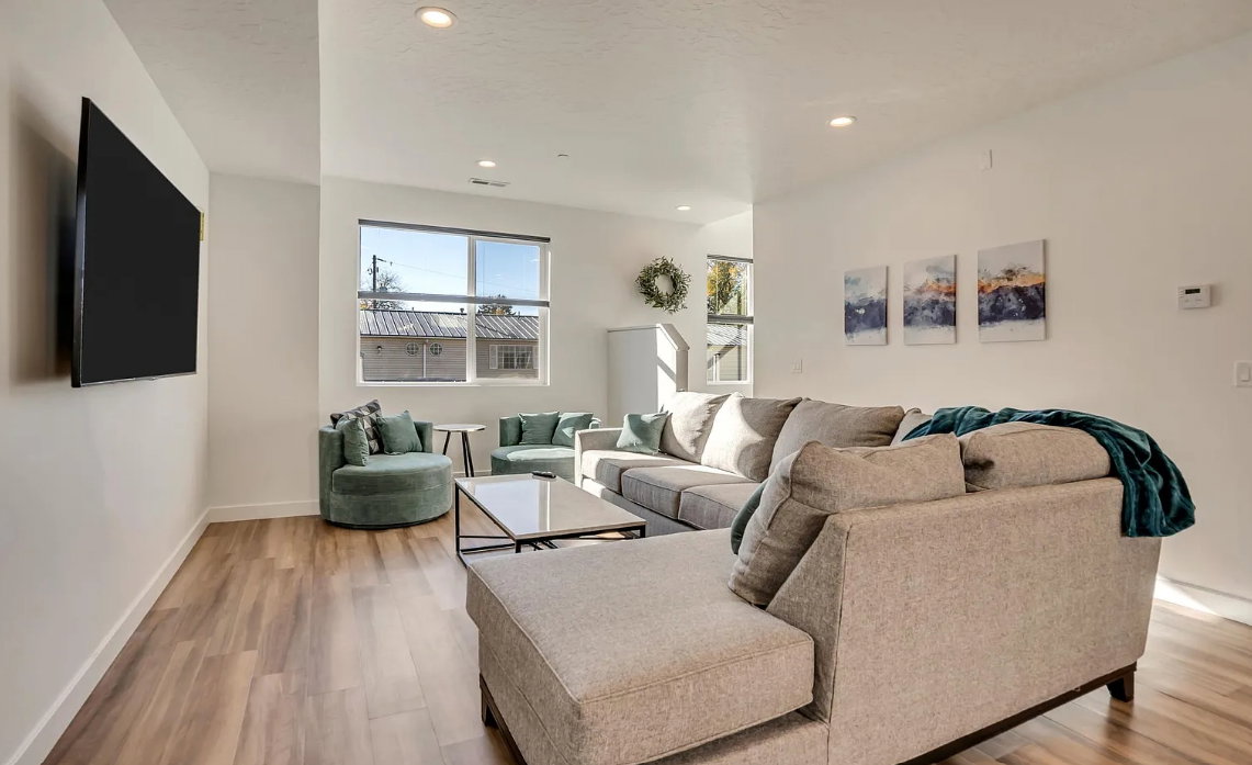 Living area featuring wood-finish flooring, recessed lighting, and a large window