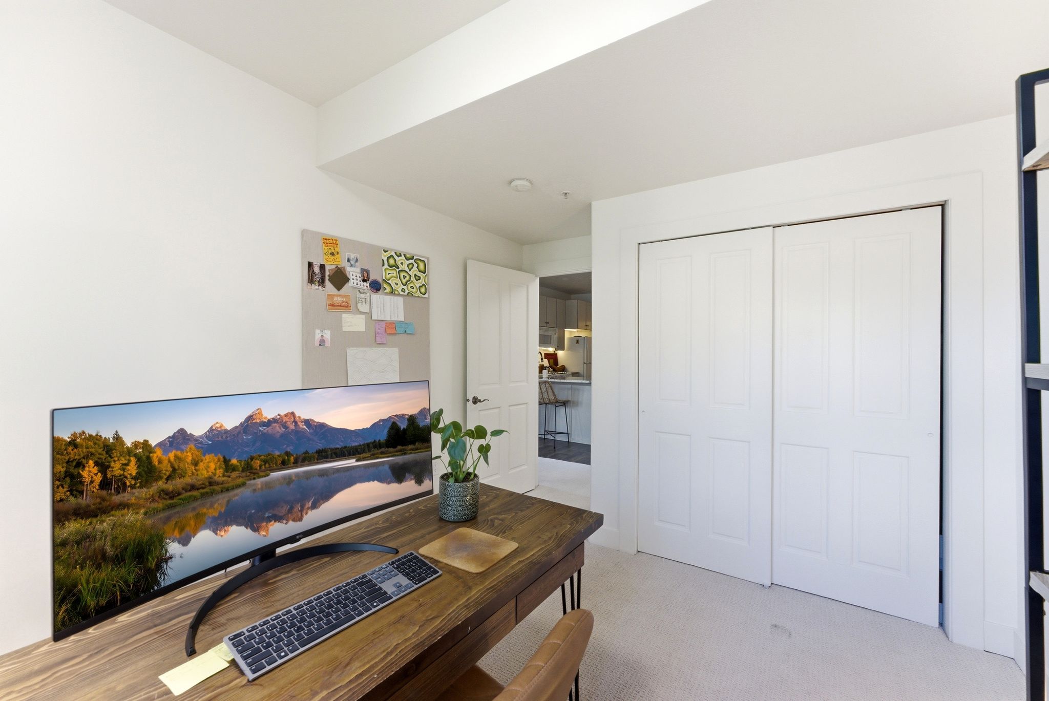 Versatile room featuring white walls, light-colored carpet, and a built-in closet with bi-fold doors