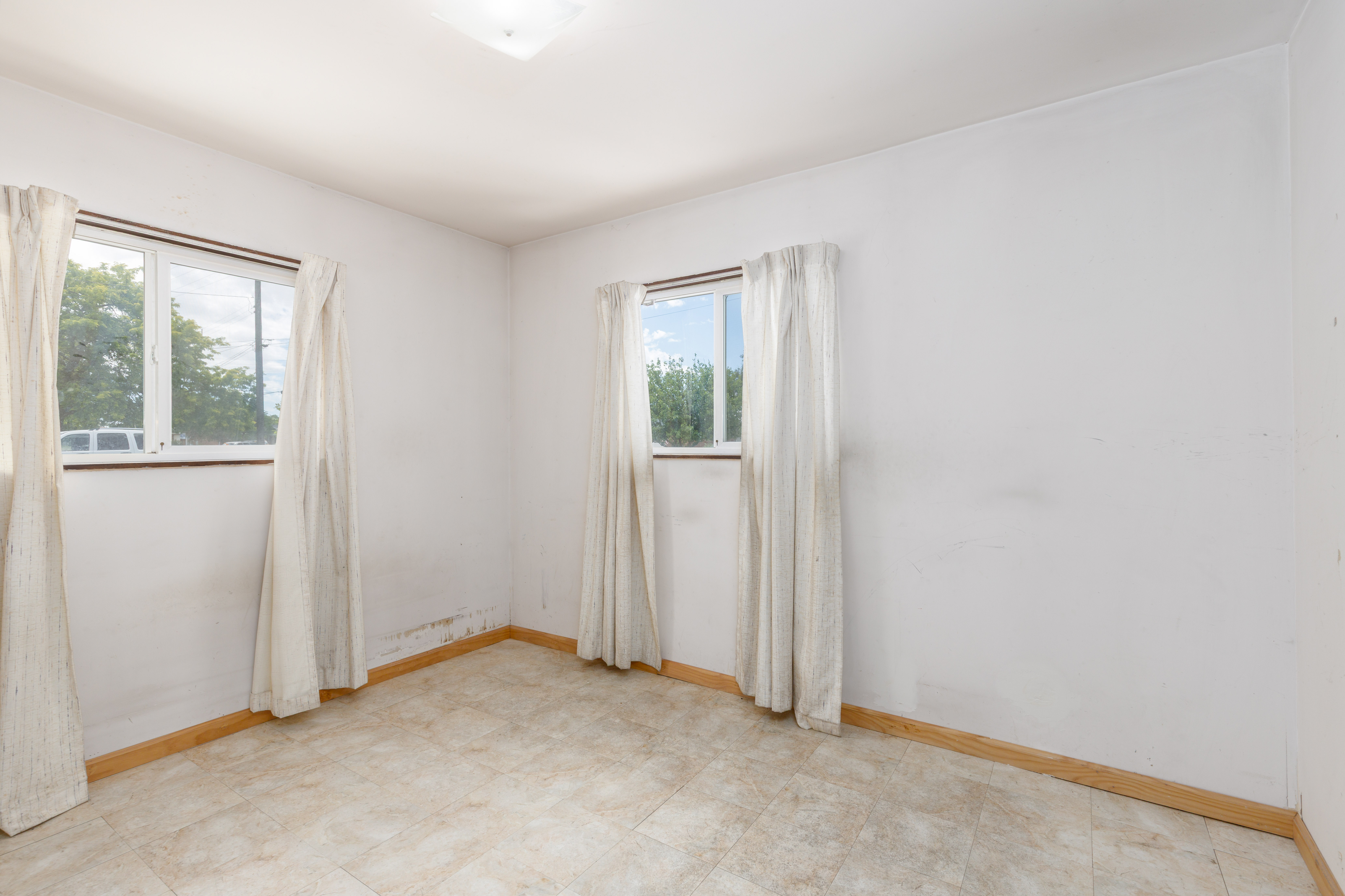 Bright interior space featuring two windows, recessed lighting, and tile flooring