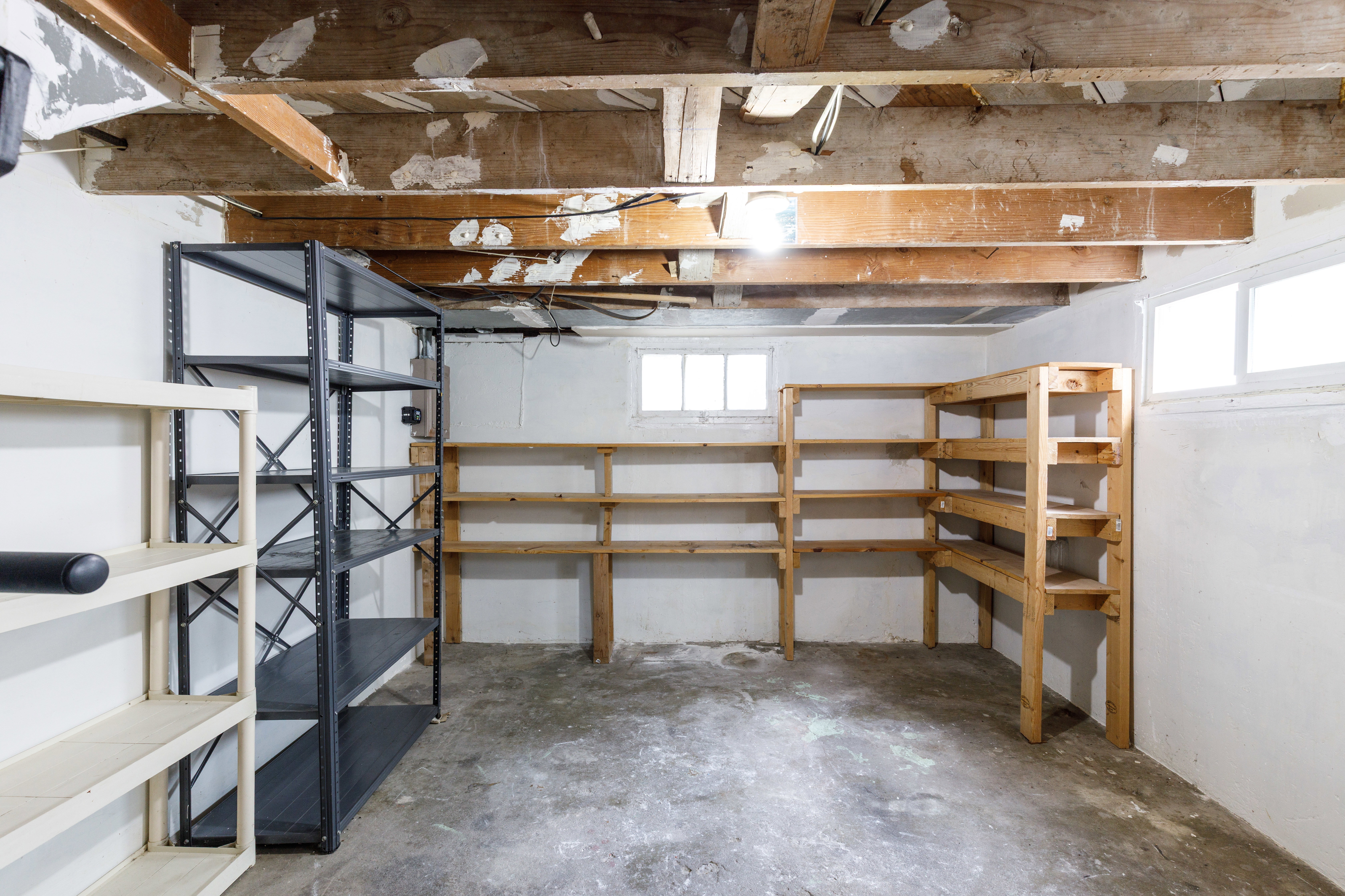 Unfinished basement featuring exposed wood ceiling joists and a concrete floor