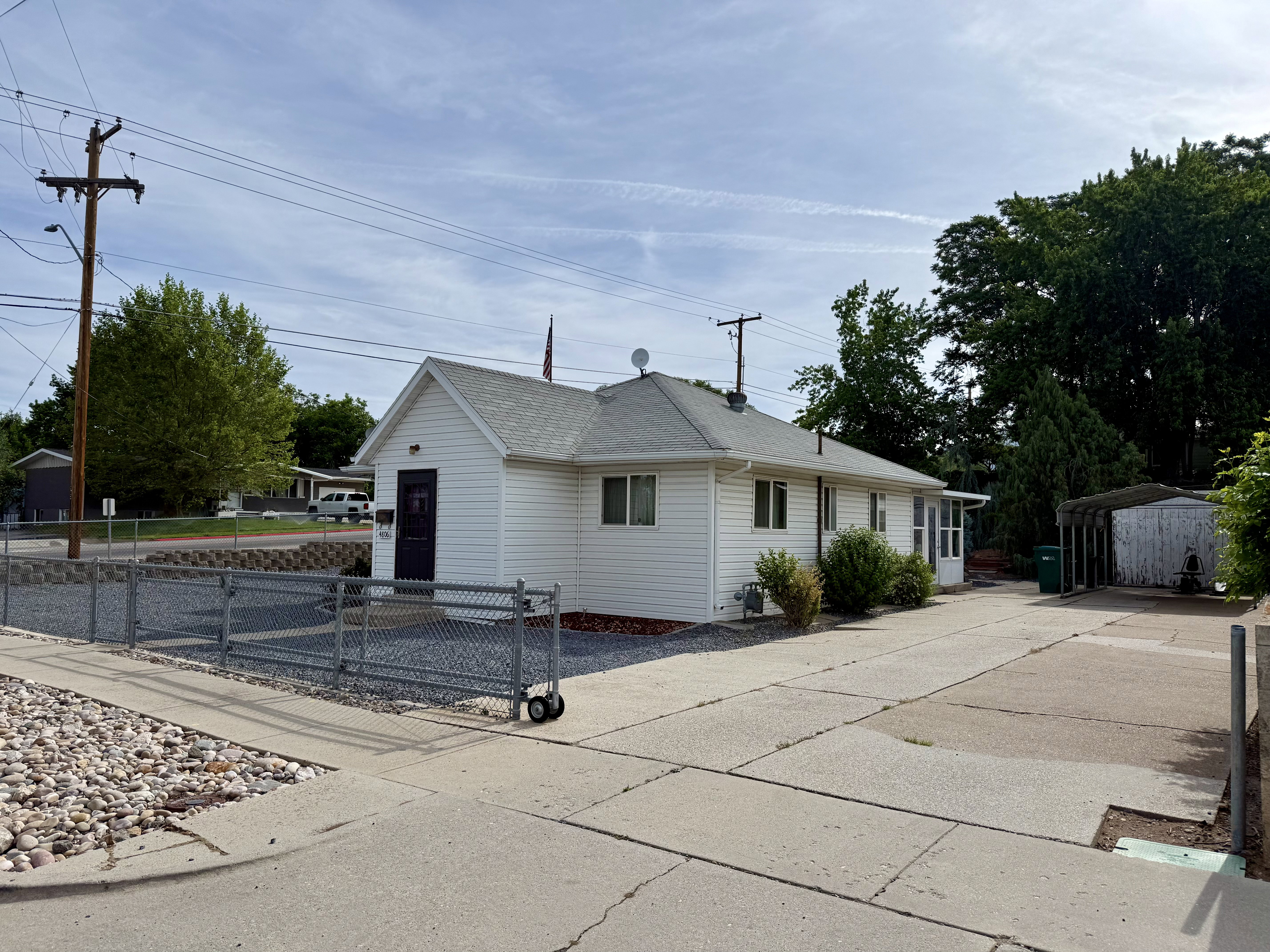 White siding exterior with a dark entry door and white trim