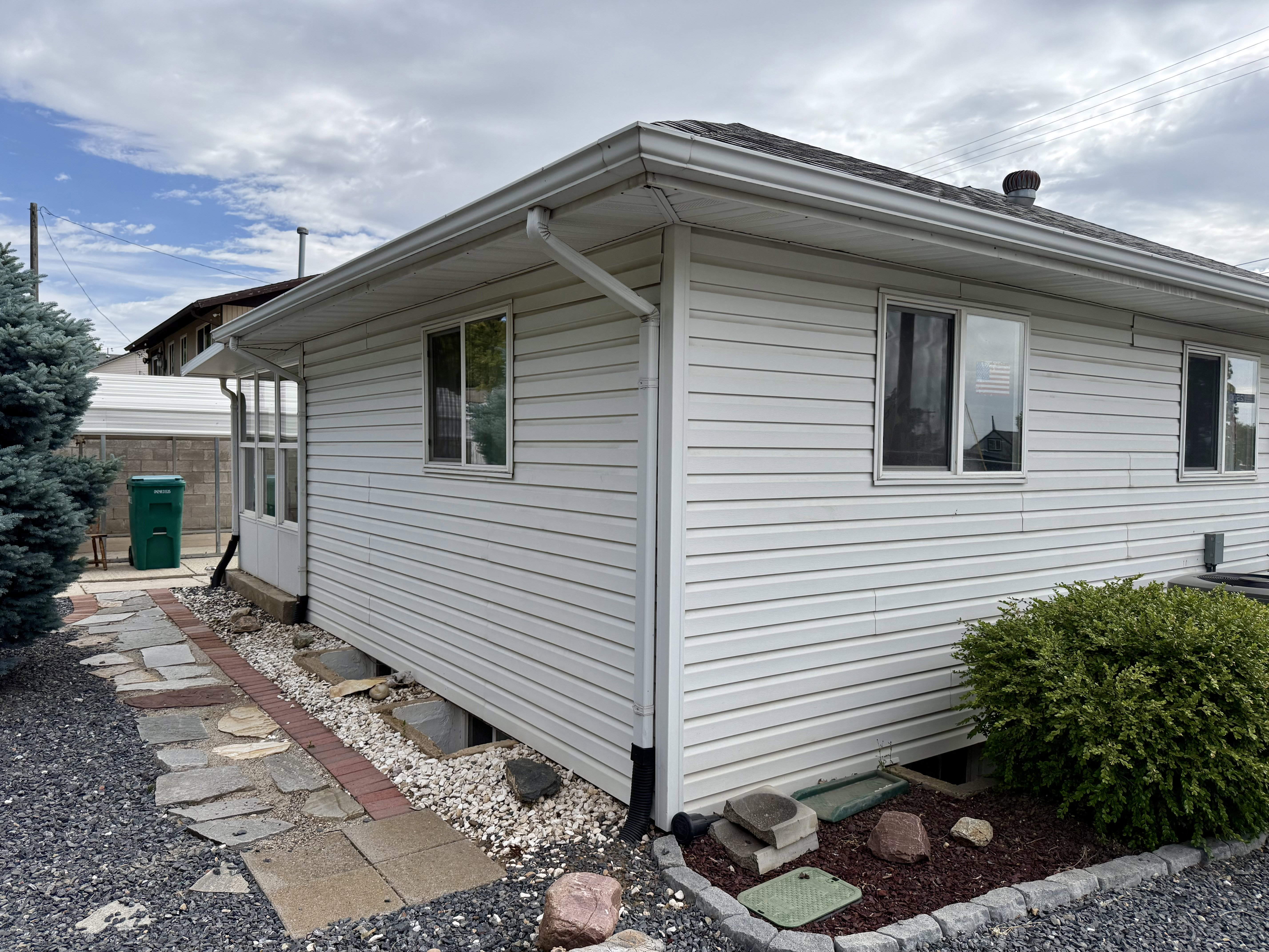 White vinyl siding exterior with multiple windows and a white gutter system