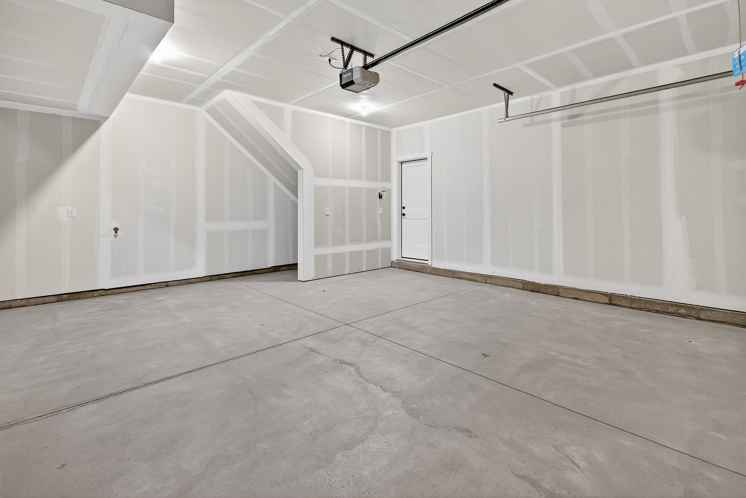 Spacious garage featuring a concrete floor, high ceilings, and a built-in overhead door opener