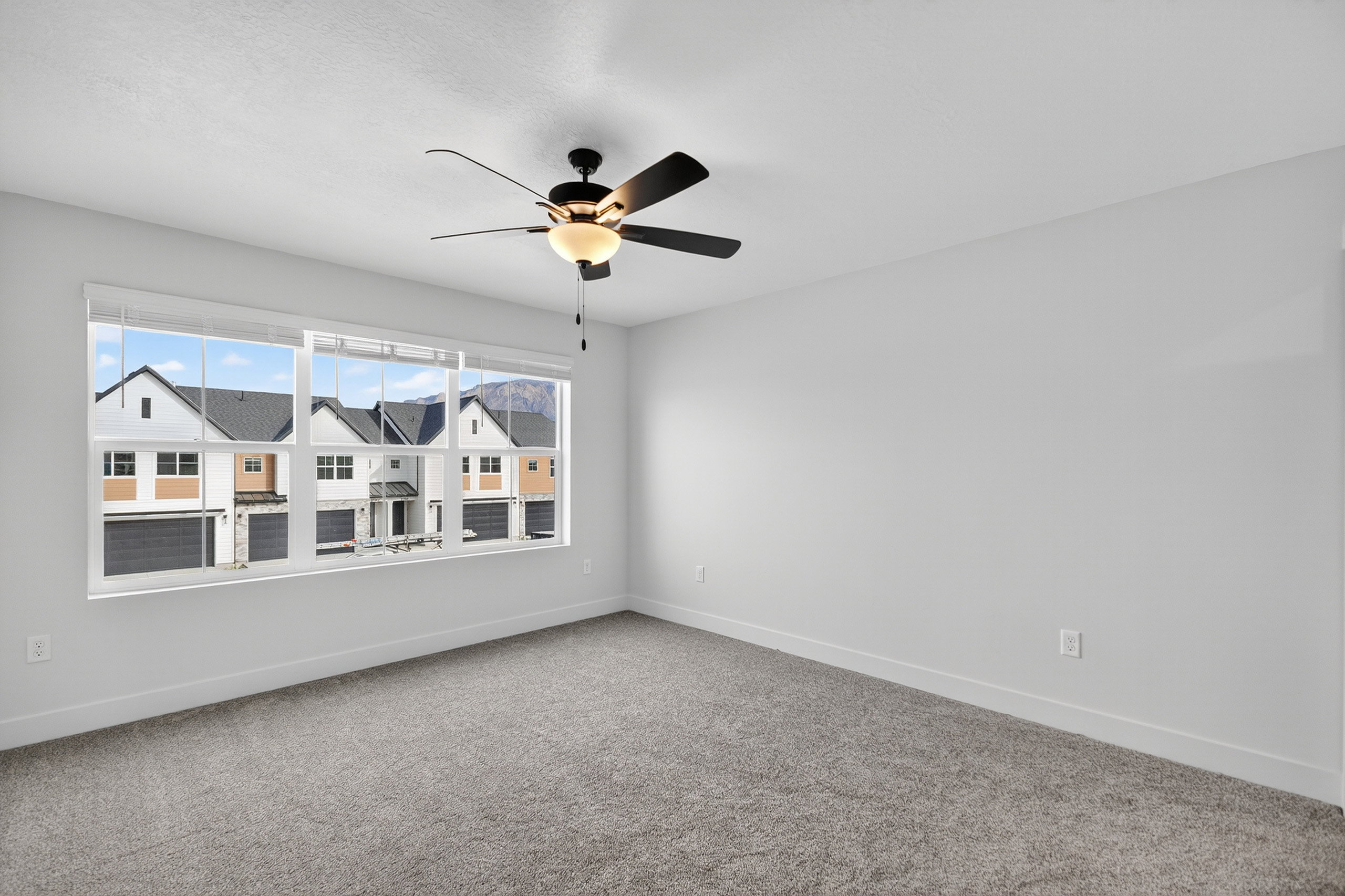 Spacious room with light gray carpeting and white walls