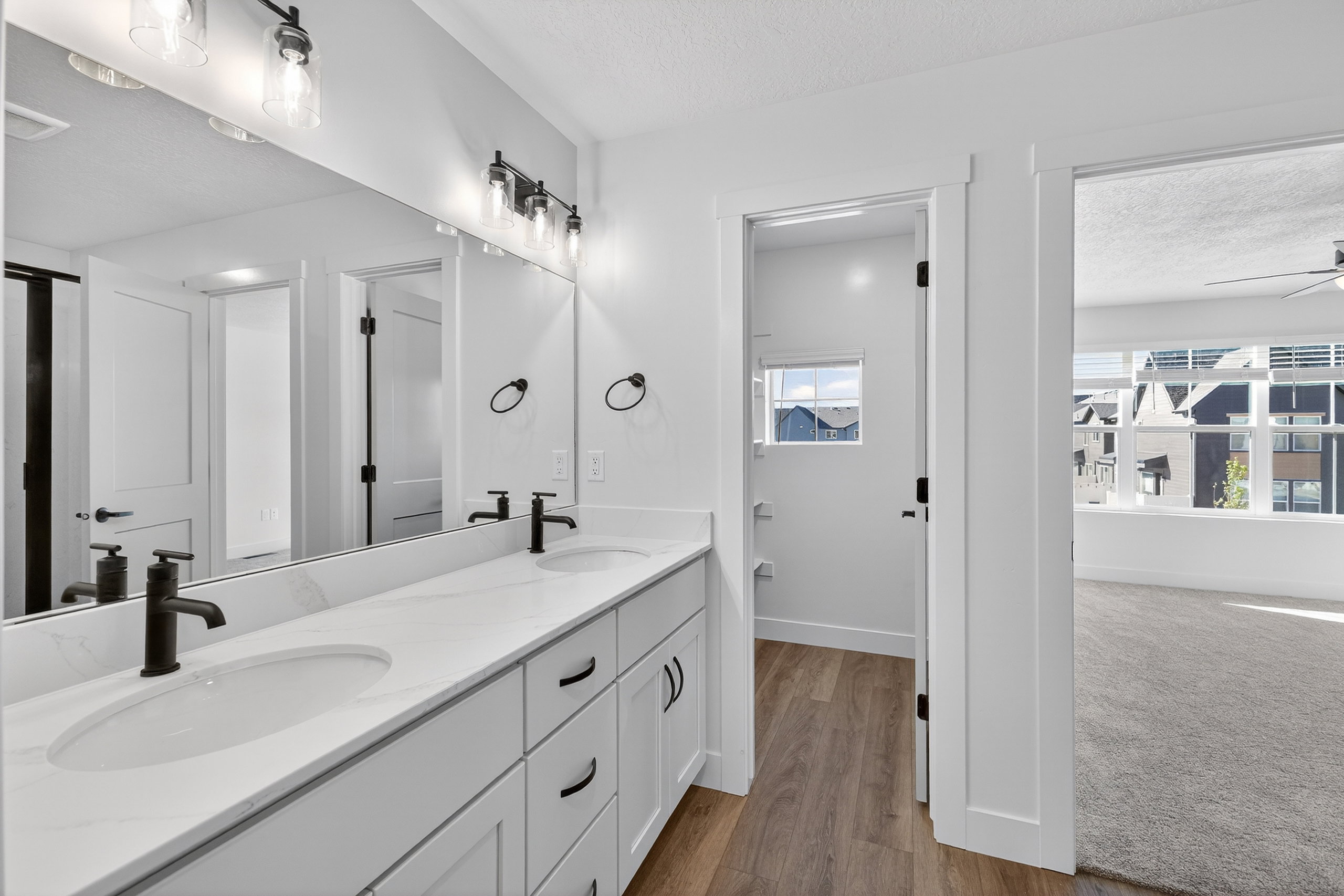 Double vanity with matte black fixtures, undermount sinks, and a large wall mirror