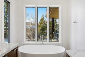 Freestanding soaking tub with floor-mounted faucet