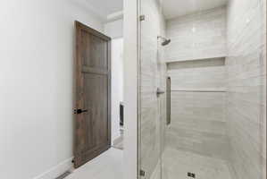 Walk-in shower featuring subway tile surround, recessed shelf, glass enclosure, and brushed nickel fixtures
