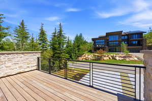 Expansive outdoor deck featuring wood-finish flooring and a contemporary metal railing system