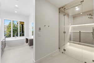 Contemporary bathroom featuring a spacious glass-enclosed shower with multiple showerheads, an integrated bench, and accent lighting