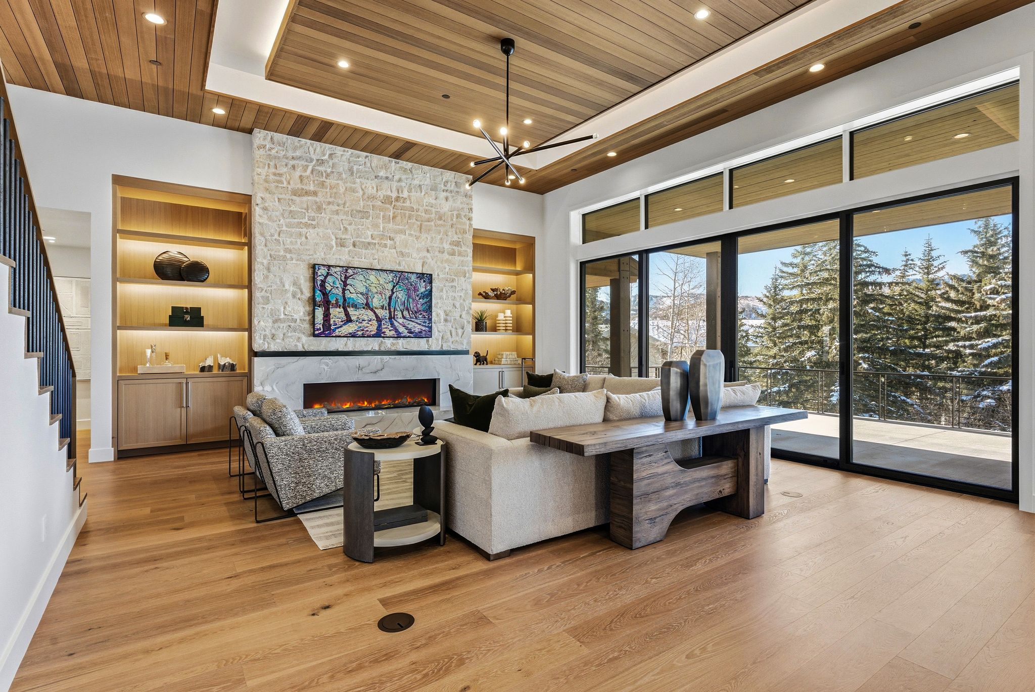 Spacious living area featuring extensive wood-finish flooring and a wood-paneled ceiling with recessed lighting