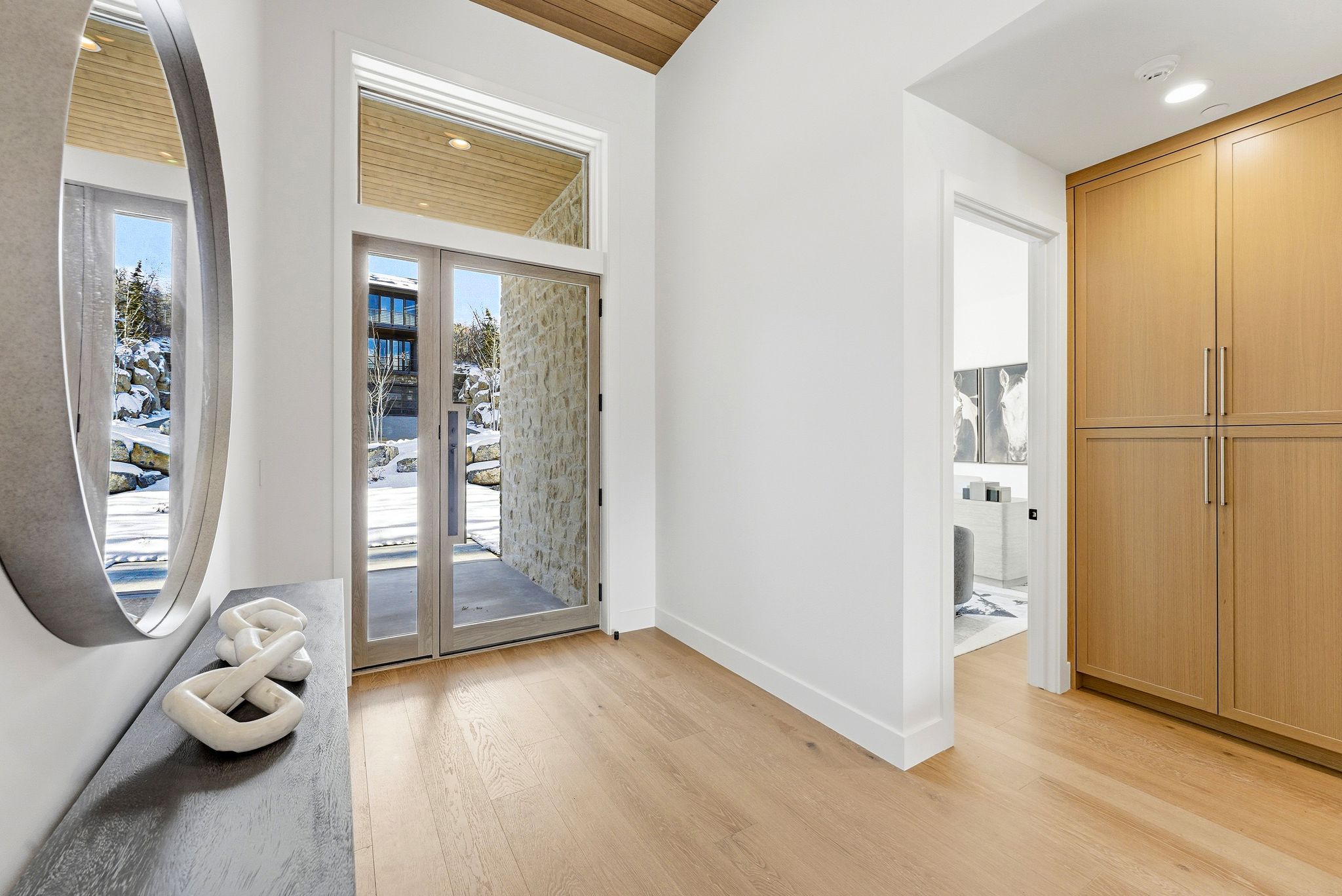 Entryway featuring a vaulted wood-paneled ceiling, light wood-finish flooring, and a full-light double entry door with transom