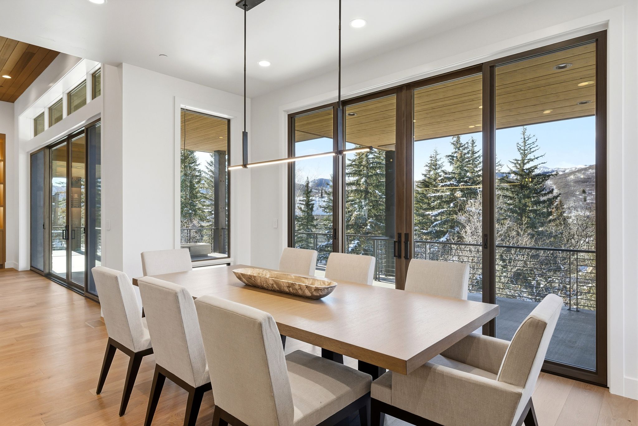 Dining area featuring a contemporary linear chandelier and wood-finish flooring