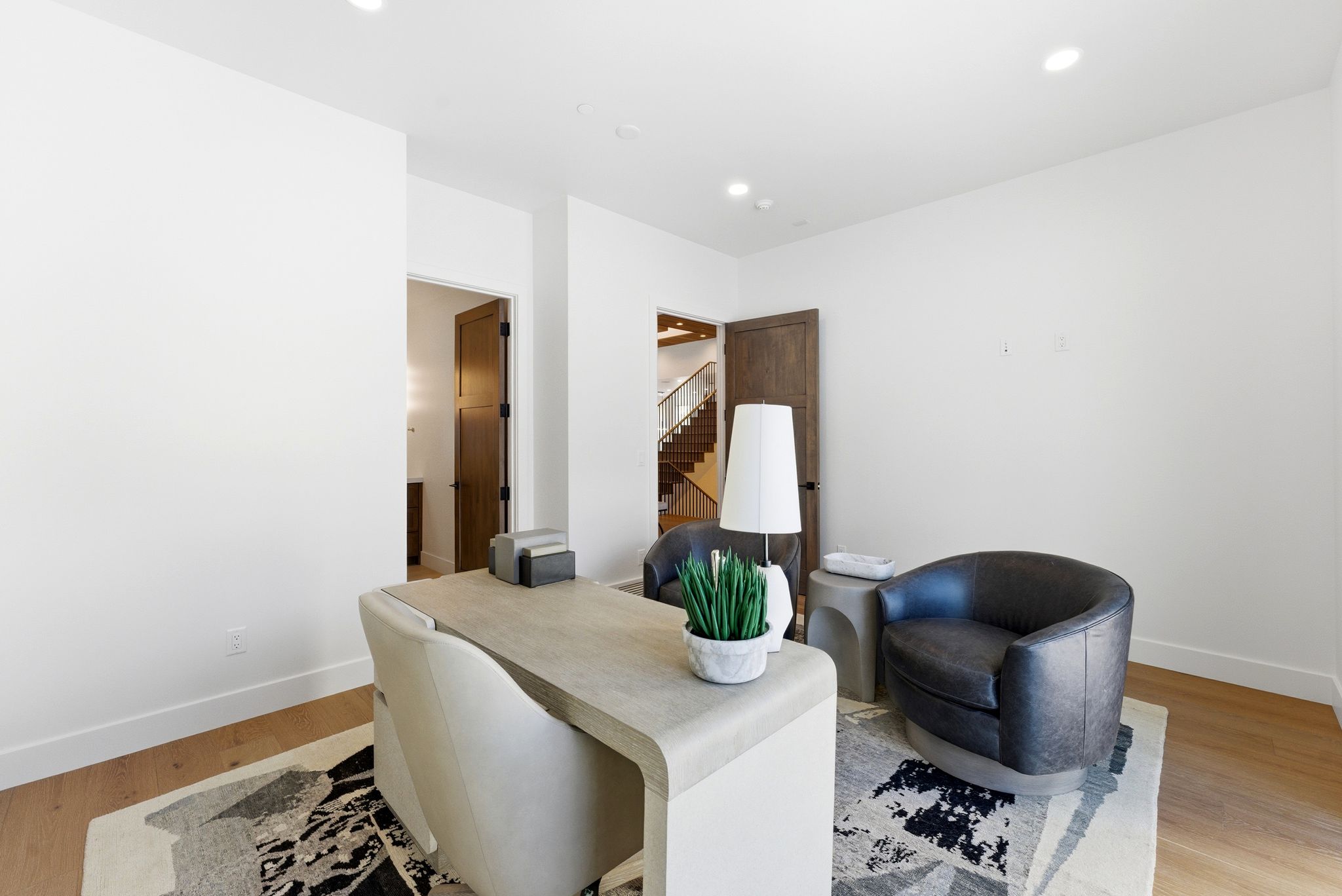 Spacious room featuring light wood-finish flooring, recessed lighting, and white walls