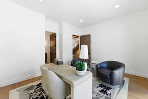 Spacious room featuring light wood-finish flooring, recessed lighting, and white walls