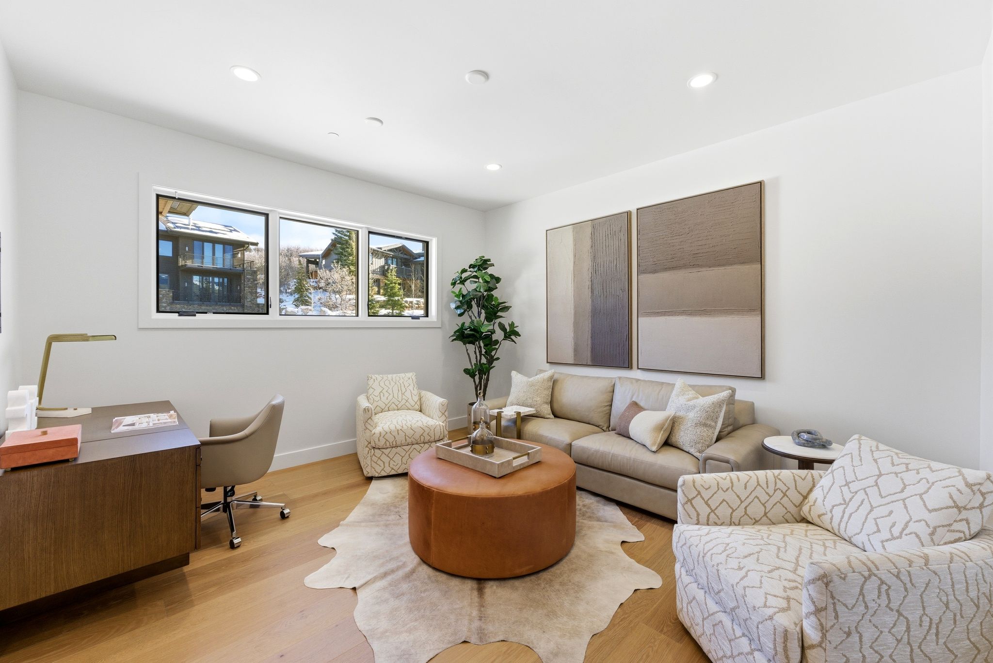 Light wood-finish flooring complements white walls and recessed lighting throughout this versatile space