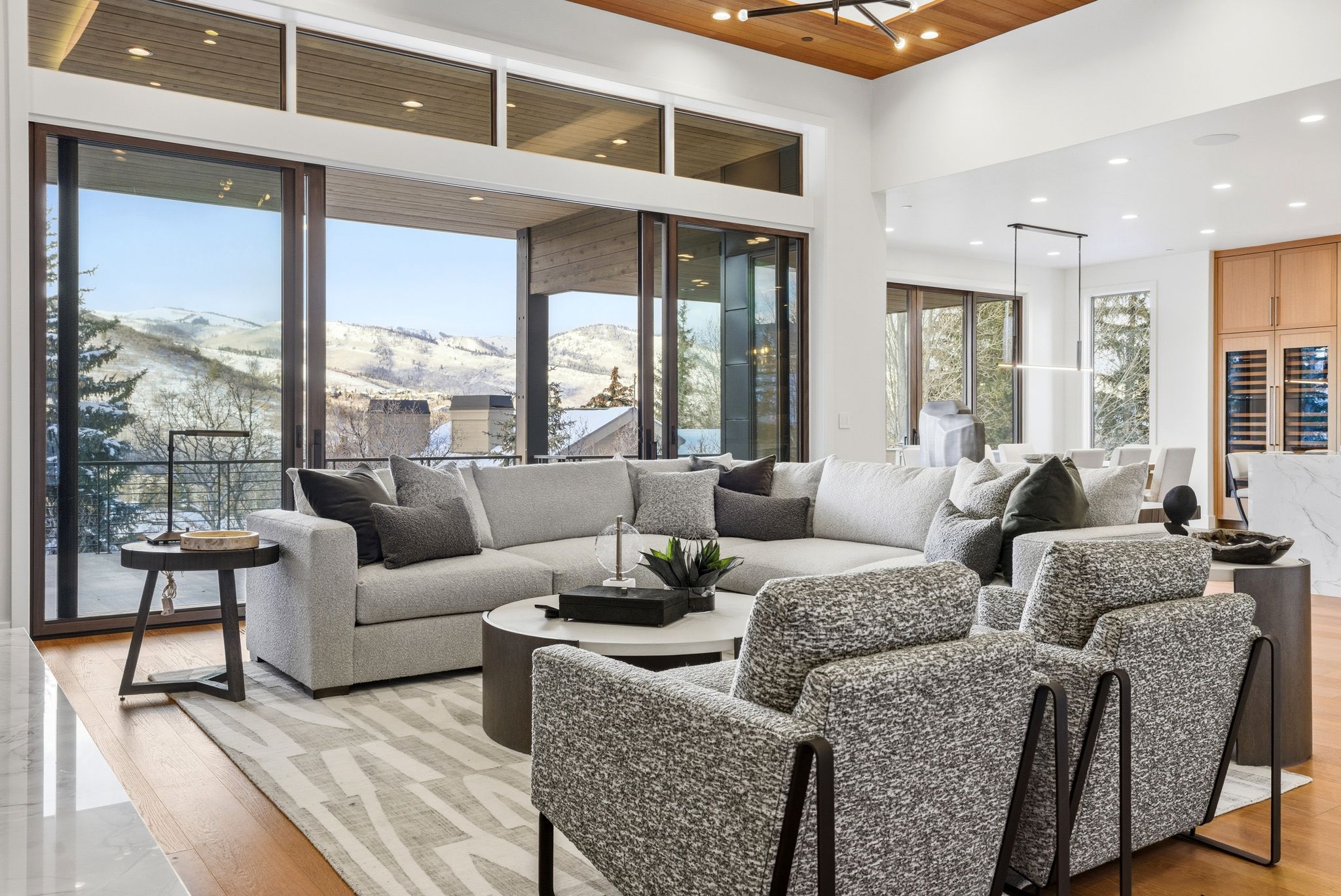 Open-concept living area featuring large format sliding glass doors, a wood-finish ceiling, recessed lighting, and rich wood-finish flooring