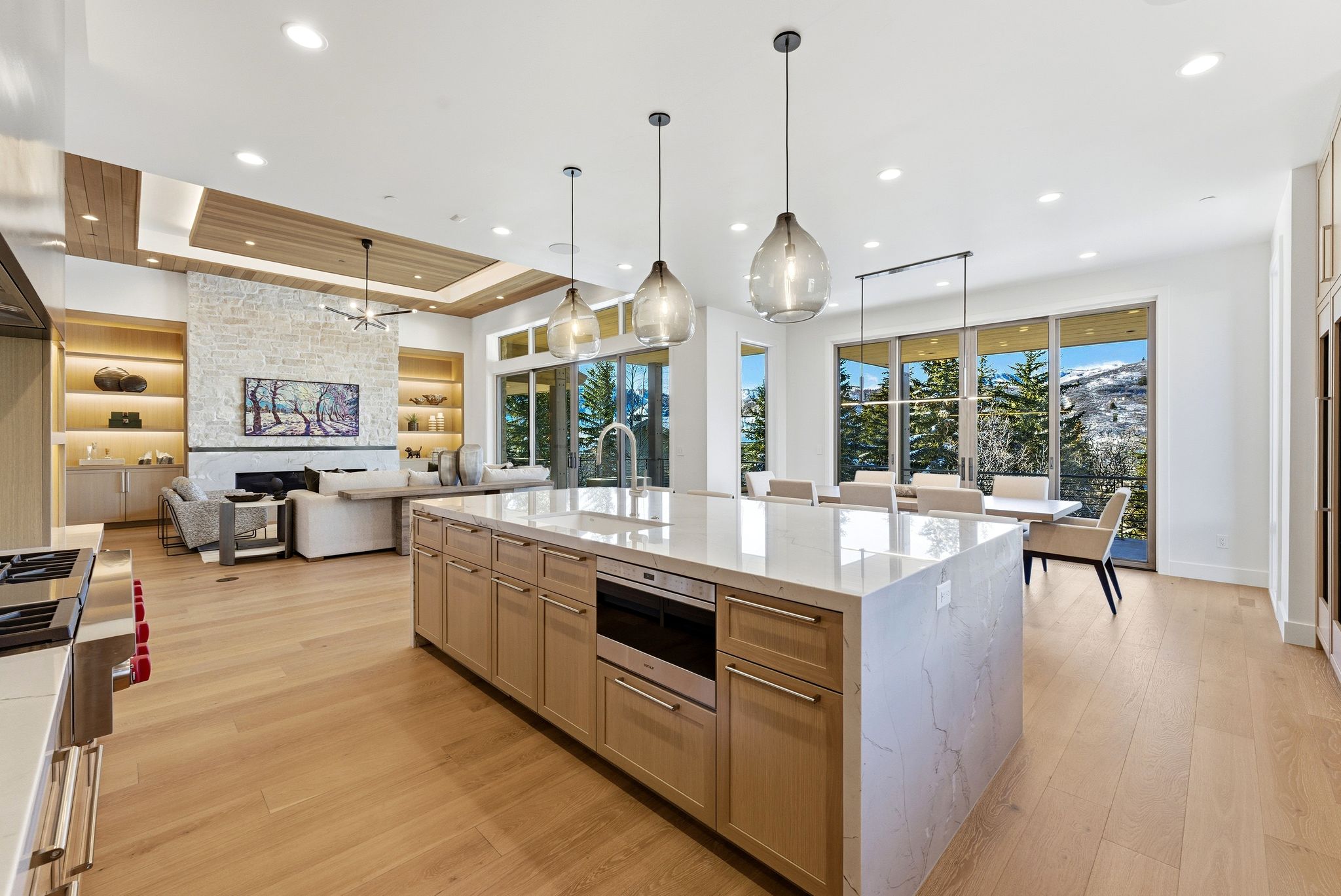 Gourmet kitchen island with an integrated sink, built-in microwave, and stone waterfall countertop