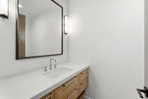 Contemporary bathroom vanity featuring a light wood finish, integrated sink, and brushed nickel hardware