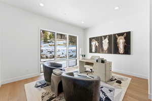 Spacious room featuring floor-to-ceiling windows, wood-finish flooring, recessed lighting, and a neutral color palette