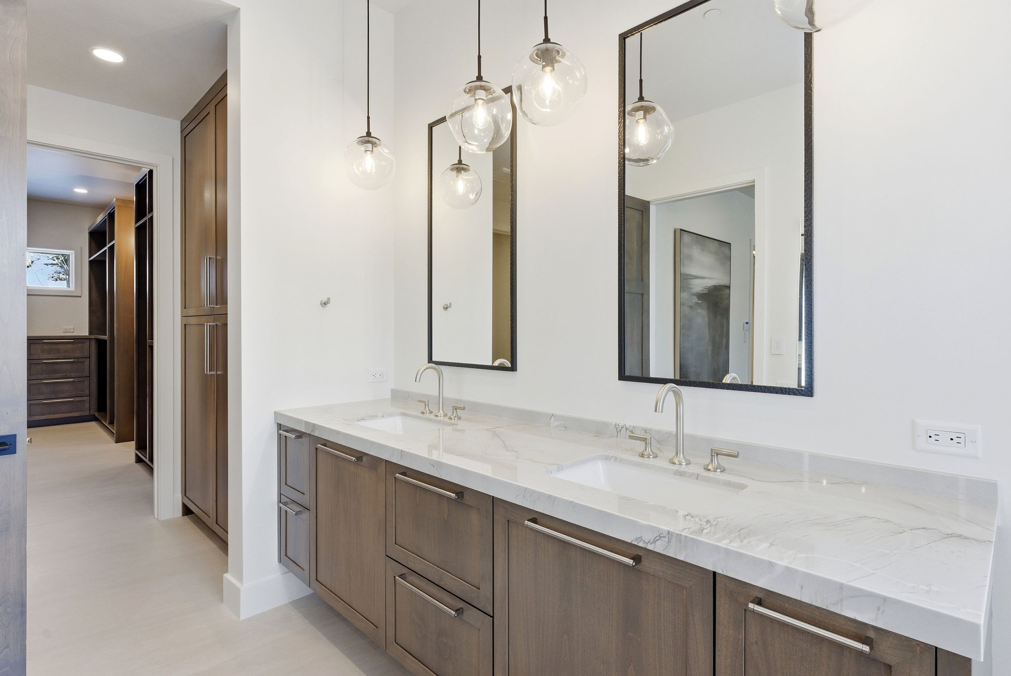 Double vanity with marble-finish countertop, undermount sinks, and brushed nickel fixtures