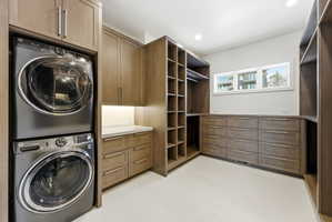 Dedicated laundry area with stacked appliances, complemented by extensive built-in cabinetry and drawers