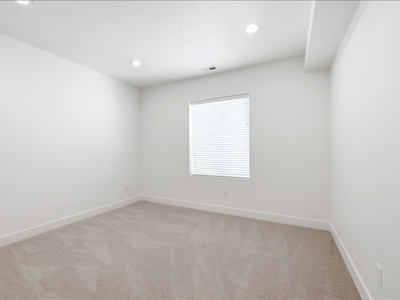 Bright room featuring light neutral carpeting and crisp white walls
