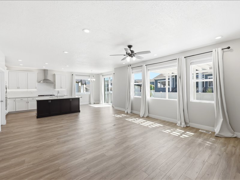 Open-concept living space featuring wood-finish flooring, recessed lighting, and a ceiling fan