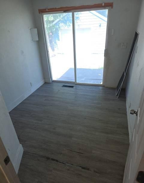 Room with wood-finish flooring and a sliding glass door