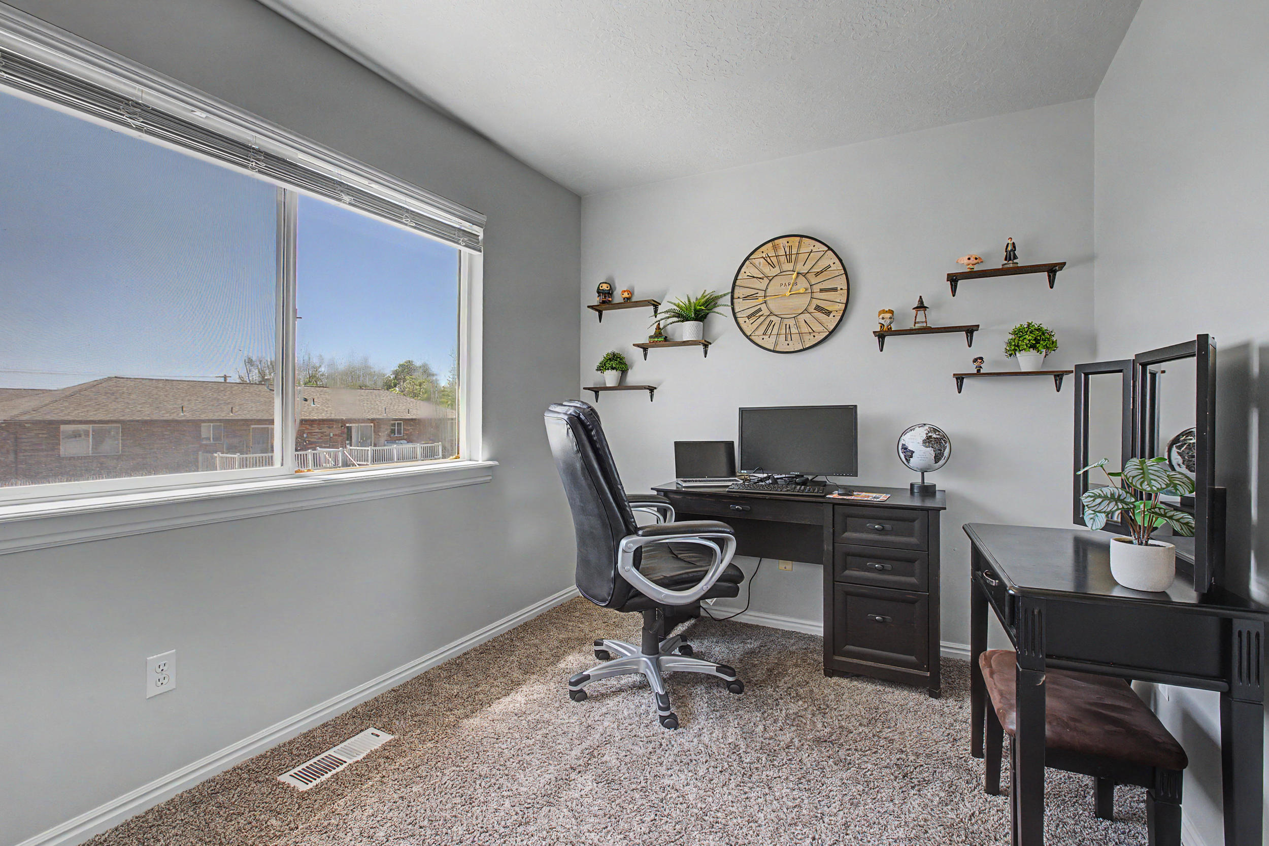 Room featuring a large window, light gray wall paint, and textured carpet flooring
