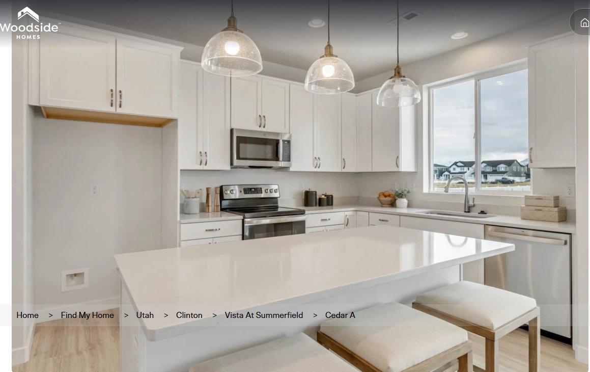 Modern kitchen featuring a large central island with seating, white shaker cabinetry, stainless steel appliances, and light-toned countertops. These pictures are of another home.
